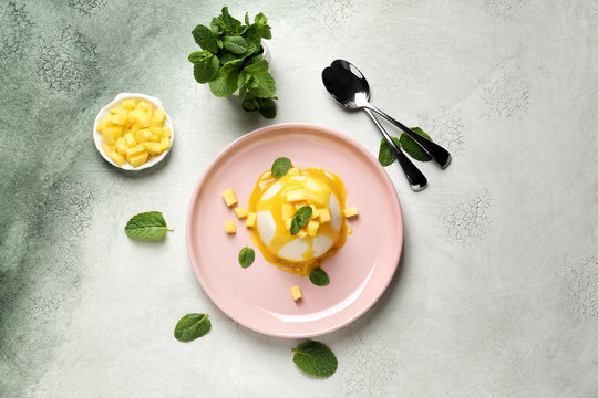 Plate with tasty panna cotta on light background