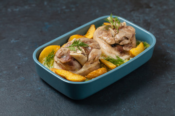 Boiled knuckle, served with cabbage and baked potatoes. Front view. Darkblue background. Dark mod.