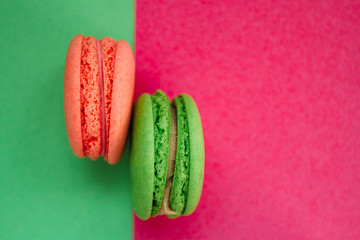 Sweet French desserts macaroons of different colors or macarons on bright multi-colored background. 