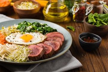 Korean beef with sprouts, spinach and fried egg.