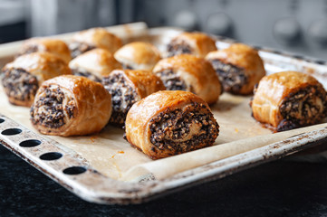 Crispy freshly baked cookies with poppy seeds on a baking tray.