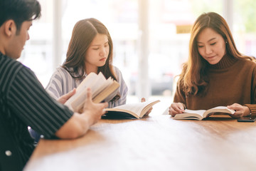 Group of people sitting and enjoyed reading book together on wooden table