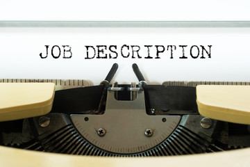 Job description word typed on a yellow vintage typewriter. Business concept.