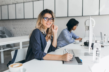 Beautiful female office worker carrying out administrative work for company. Indoor portrait of...