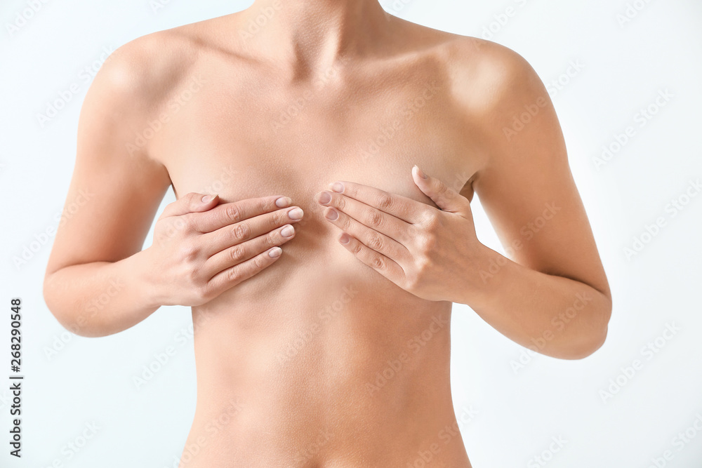 Poster Naked woman on light background. Concept of breast augmentation