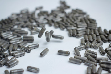 Set of grey capsules pills on white background. Medical preparations.
