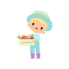 Cute Boy in Overalls, Rubber Boots and Hat Holding Wooden Box Full of Vegetables, Young Farmer Cartoon Character Engaged in Agricultural Activities Vector Illustration