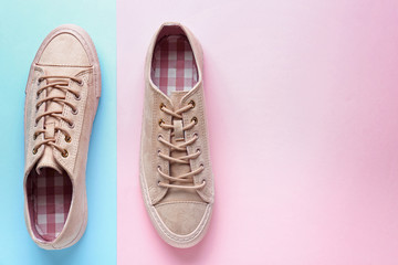 Fototapeta na wymiar Pair of stylish casual shoes on color background