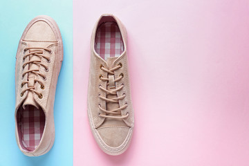 Pair of stylish casual shoes on color background