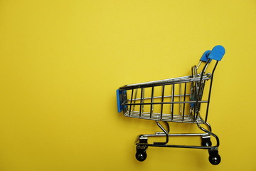 Mini trolley cart with space copy on yellow background