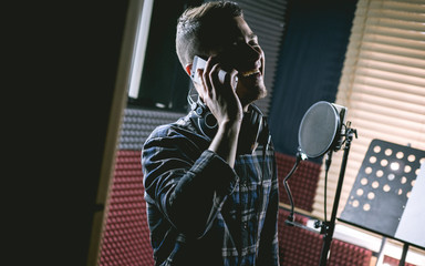 man in recording studio speaking by phone