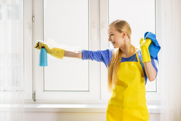 Woman cleaning window at home