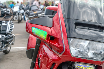 Close up front of a new red motorcycle. Mirror, protective glass, motorcycle headlights close up