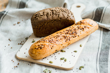 Freshly baked white and grey bread on dark grey fabric with seed