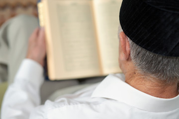 Obraz premium An old man reading the book. Selective focus