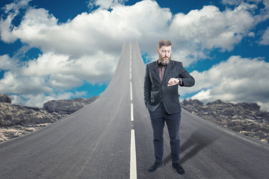 Businessman standing on road that goes up to the sky