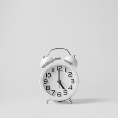 White vintage alarm clock on white background.