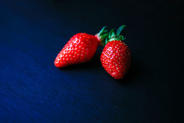 Two delicious strawberrys on black background