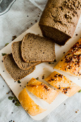 Freshly baked white and grey bread on dark grey fabric with seed