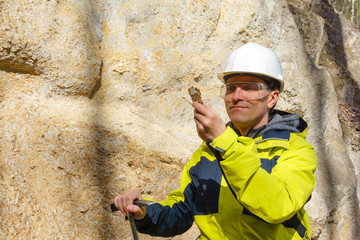geologist examines a sample of stone outdoor - obrazy, fototapety, plakaty
