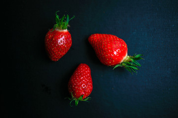 Three delicious strawberrys on black background