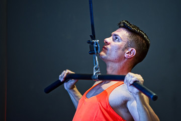 Young muscular athlete performing push ups with machine, Fitness.