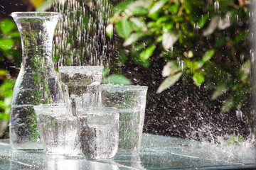 Glasses full of water for the refreshment on a hot summer day. Rain water on a table