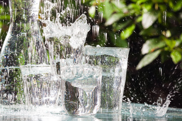 Glasses full of water for the refreshment on a hot summer day. Rain water on a table