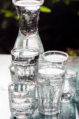 Glasses full of water for the refreshment on a hot summer day. Rain water on a table