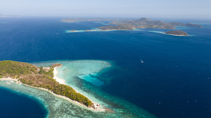 Fototapeta premium aerial seascape tourists enjoy the tropical beach. tropical island with sand beach, palm trees. Malcapuya, Philippines, Palawan. Tropical landscape with blue lagoon, coral reef