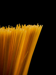Grop of raw spaghetti on black background, copy space for text.