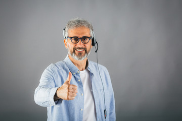 middle aged man showing thumb up wearing headset