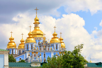 Fototapeta na wymiar The famous Golden-domed Michael's Cathedral in Kiev in the spring against the blue cloudy sky