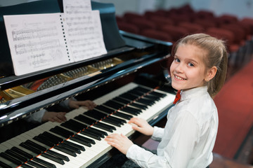 little girl playing concert piano © cherryandbees