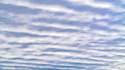 Panorama Defocused view of a boundless blue sky filled with white puffy clouds