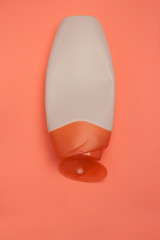 Beauty, decorative cosmetics bottles. Peach and purple colors background, flat lay, top view, minimalistic pop-art style