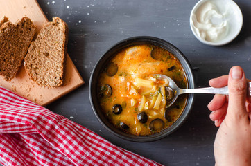 pickle soup with olives, tomatoes and lemon served with cream and bread. Proper nutrition diet healthy food