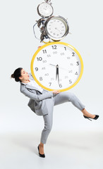 Young woman can't organize her worktime. Forced to constantly stay and work longer. Holding the big...