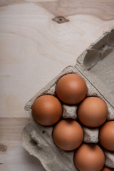 Packing chicken eggs on a wooden background close up