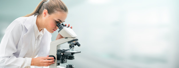 Scientist researcher using microscope in laboratory. Medical healthcare technology and pharmaceutical research and development concept.