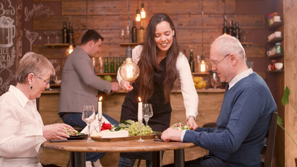 Senior couple looking at the food that their waiter is serving them
