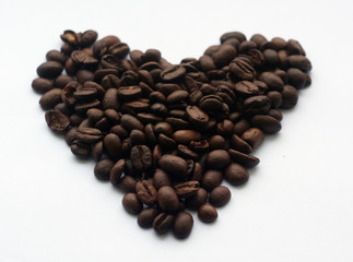 Coffee beans in heart form on white.