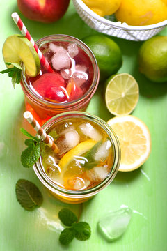 Iced tea, summer fruit refreshment drink or peach, lime cocktails