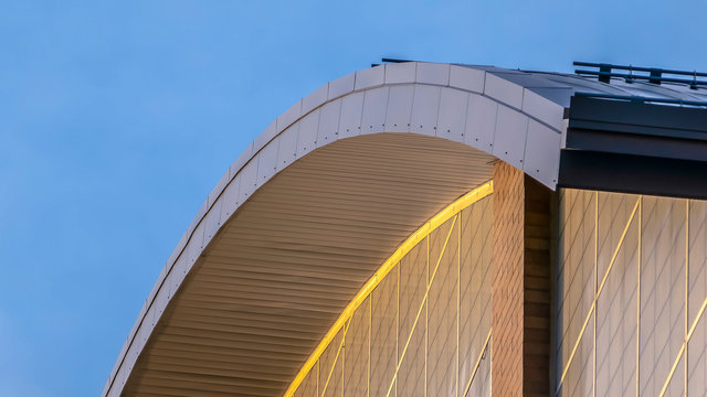 Clear Panorama Exterior View Of A Building With A Curved Roof Against Blue Sky Background