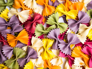 colorful Italian pasta background. Various colors of bow tie farfalle pasta. Top view.