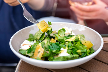 Fresh salad in a plate of vegetables and greens with mozzarella cheese pieces. Copy space