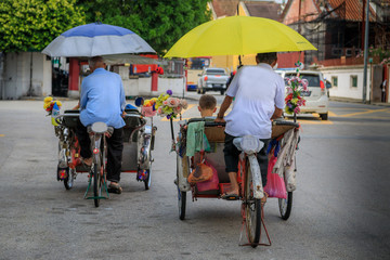 Zwei Rikschafahrer in Asien befördern  Passagiere