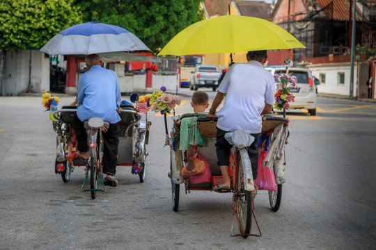 Zwei Rikschafahrer in Asien bef&ouml;rdern  Passagiere
