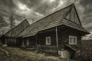Obraz premium Old cottage and dark clouds