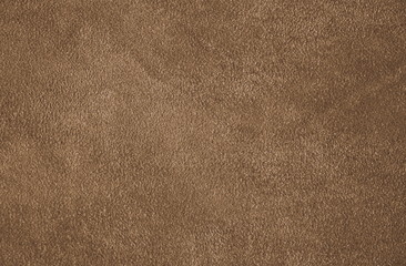 The texture of genuine suede. Brown background.  The structure of the leather material brown shades.